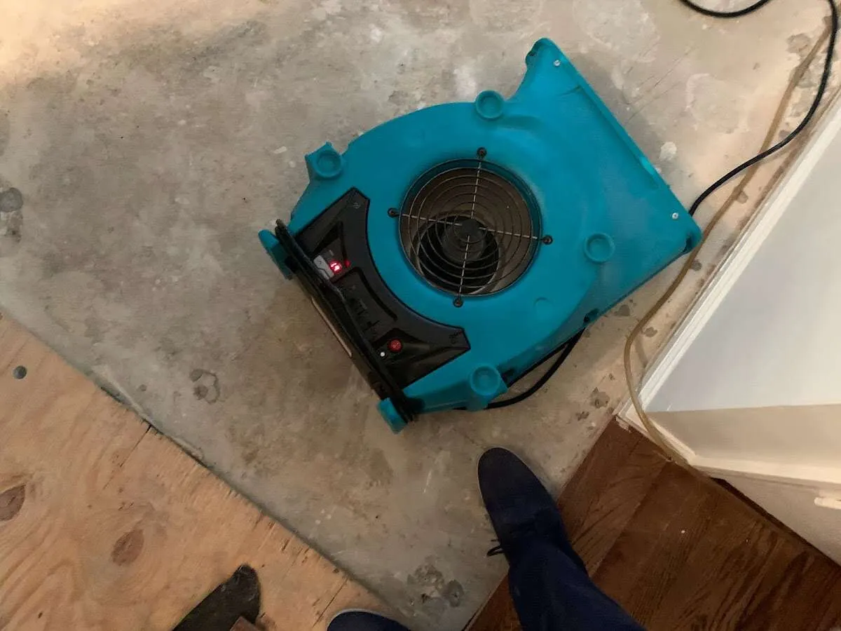 Air mover drying subfloor during Commercial Water Damage Restoration in Buckingham